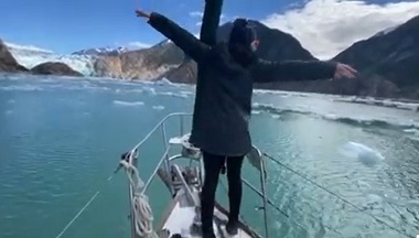 View of a glacier from bow of a sailboat.